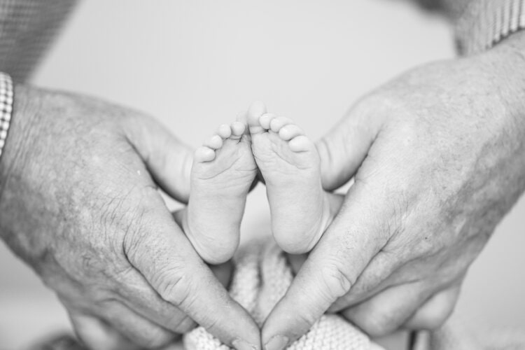 ewborn Baby's feet. Mother holding newborn baby legs