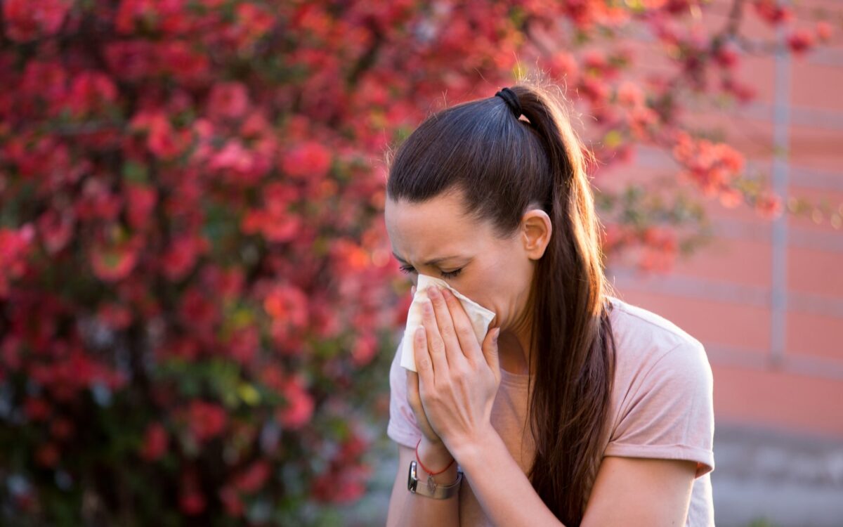 Woman sneezing into a hanky